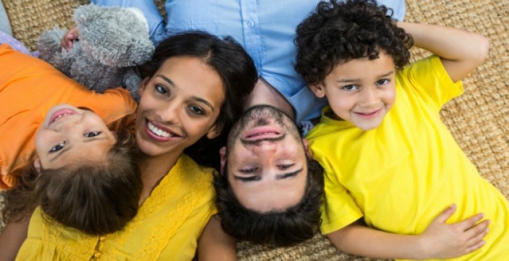 smiling-family-laying-on-carpet-and-looking-at-the-camera_13339-275156_0